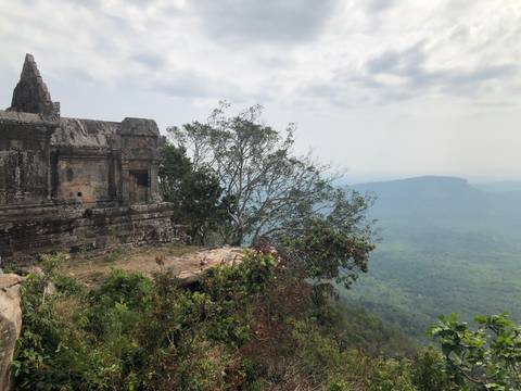Ruins on a cliff with a view of the valley below.