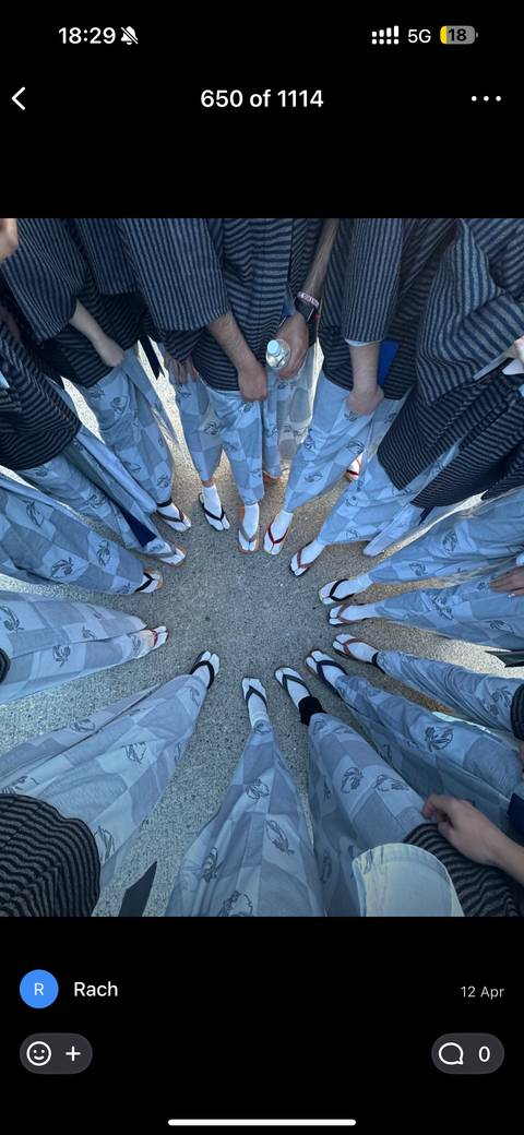       Close-up of people standing in a circle, showing their feet in sandals and socks.
  