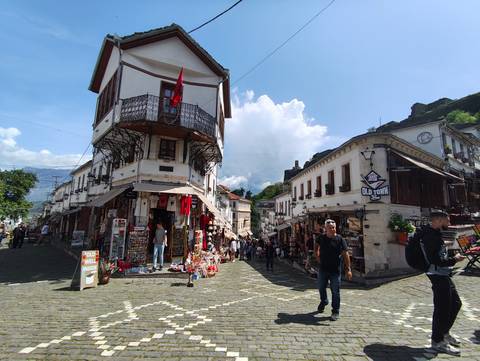 Busy street scene with shops and people in an old town.