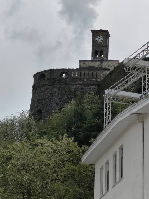 Old stone structure partly obscured by modern construction.