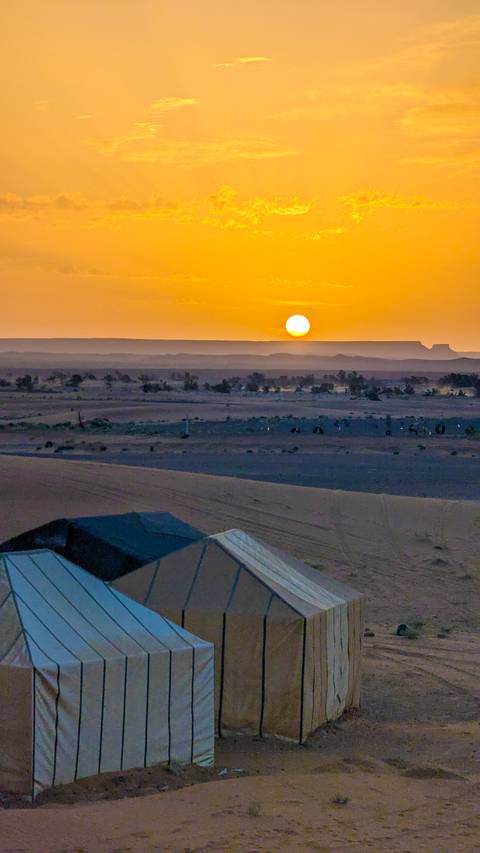 Sun setting over a desert landscape.