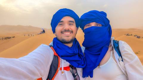 Couple in traditional attire with a desert background.