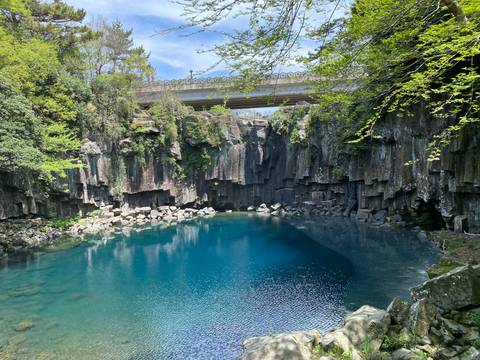 A beautiful blue pool surrounded by lush stone formations.