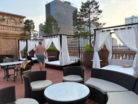 A rooftop lounge area with cabanas and a city view.