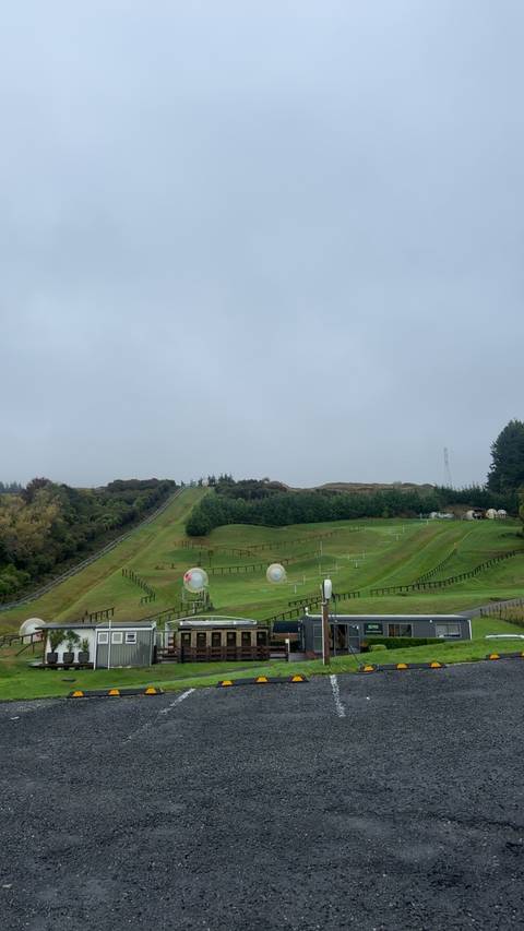       Zorbing hill with zorbs arranged across a field.
  