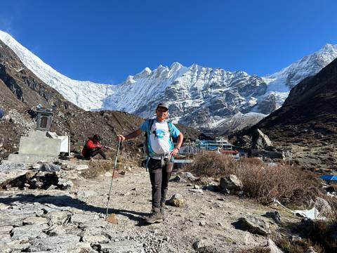 Mountaineer standing before snow-capped peaks.