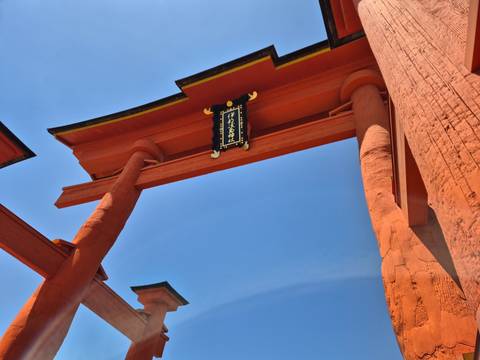       Close-up view of a red torii gate with the sky in the background.
  