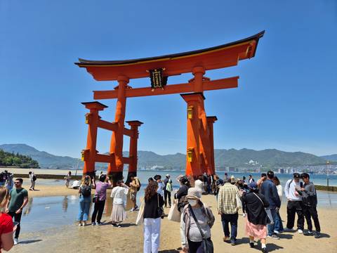       Famous red torii gate with people gathering around.
  
