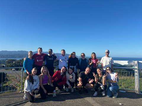       A group photo on a hilltop with a scenic background.
  