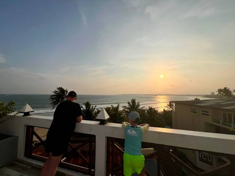       Two people viewing the sunset over the ocean.
  