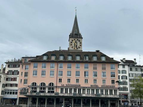 A pink building with a clock tower.