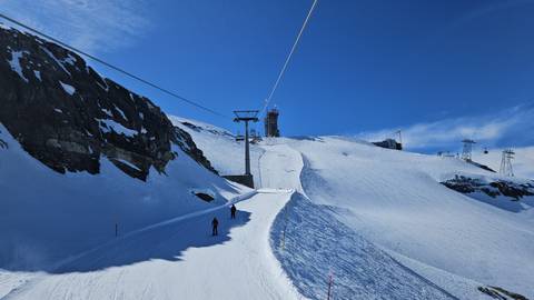 Ski slope with skiers and lift in the mountains.