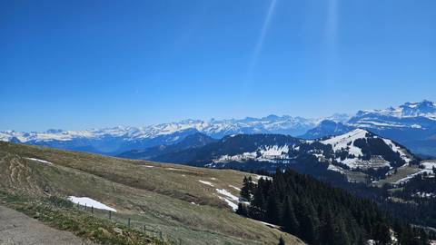       Snowy mountain range under a blue sky.
  