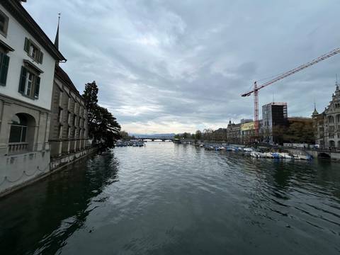 River view with historic buildings and a bridge.