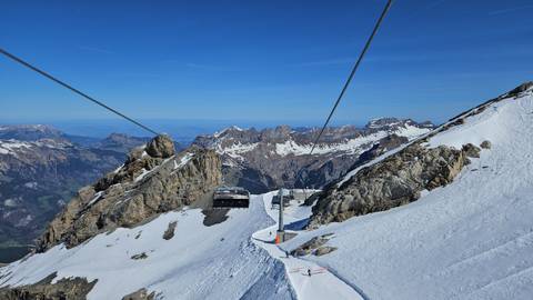 Cable cars in a snowy mountainous region.