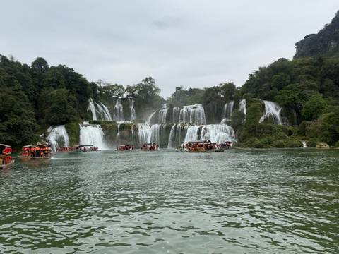 A series of waterfalls with visitors in boats.