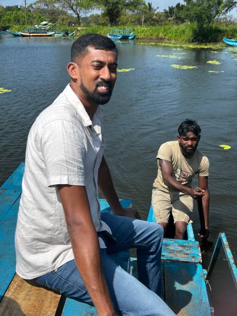 Two men on a boat on a river.