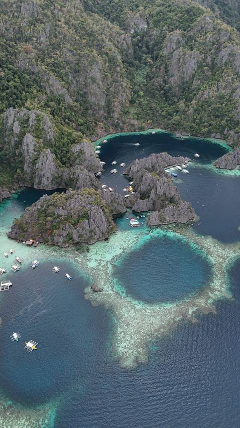       Aerial view of rocky islands with clear blue water.
  