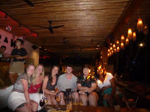       Group of people in a dimly lit bar setting.
  