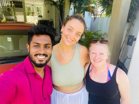 Three people smiling in an outdoor setting.