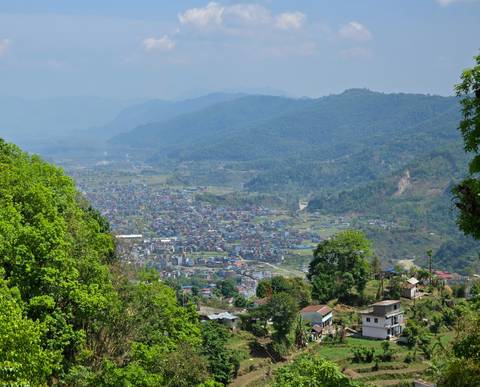       Panoramic view of a valley with scattered buildings.
  