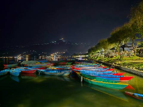       Colorful boats lined up on a lake during night time.
  