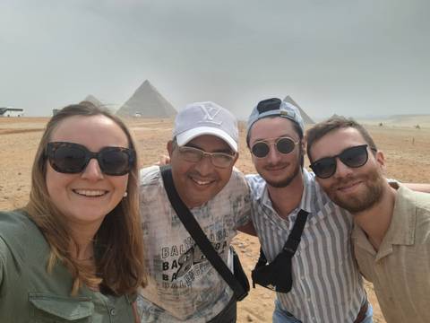 A group selfie with the pyramids in the background.