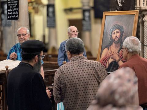      A group of people in a church setting, with religious icons and artworks.
  