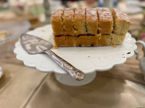 Slices of layered cake on a decorative stand with a serving utensil.