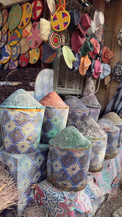 Variety of colorful spice piles at an outdoor market.