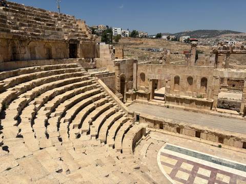       Ancient Roman amphitheater surrounded by modern buildings.
  
