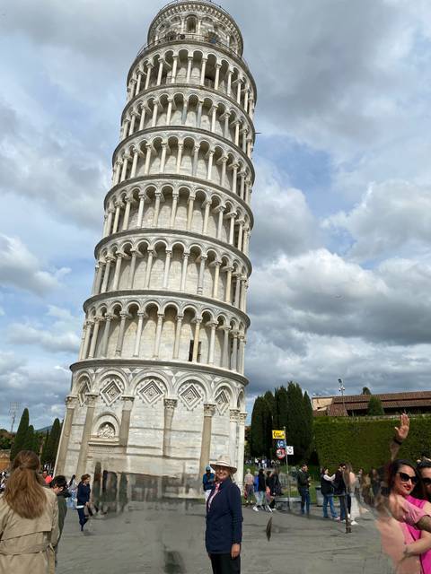 Leaning tower with decorative arches and a cloudy sky.