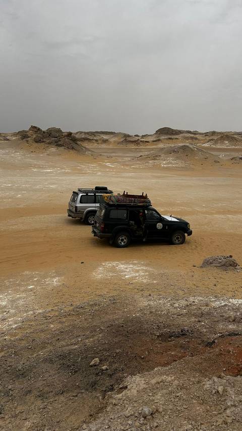 Two off-road vehicles in a desert landscape.