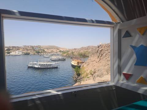 View of a river with docked boats seen through a colorful window frame.