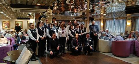 Group photo of staff and guests inside a room.