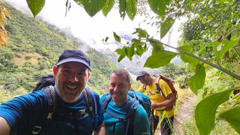 Three hikers on a forest trail taking a selfie.