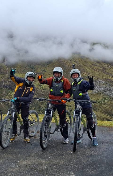 Three people on mountain bikes posing for a photo.