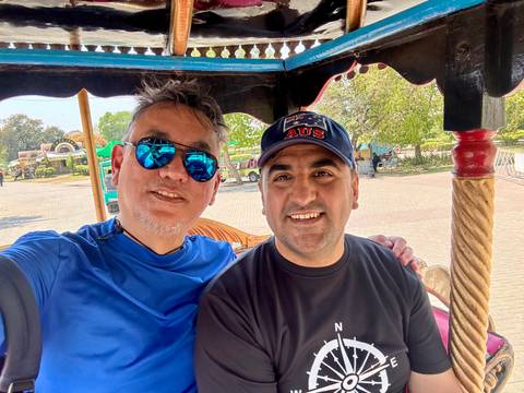       Two men taking a selfie with sunglasses and smiles.
  