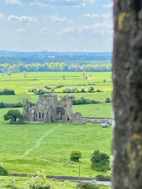       Ruins of a castle in a green field.
  