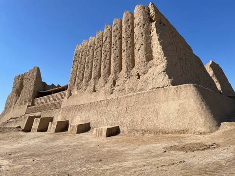 Ancient mud-brick fortress under clear blue sky.
