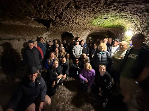 Group of people inside an underground cave or tunnel.