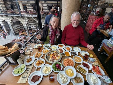 Couple enjoying a traditional Turkish meal surrounded by various dishes.