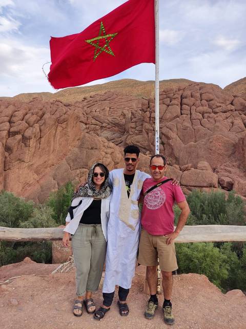 Three friends posing in front of a rocky landscape.