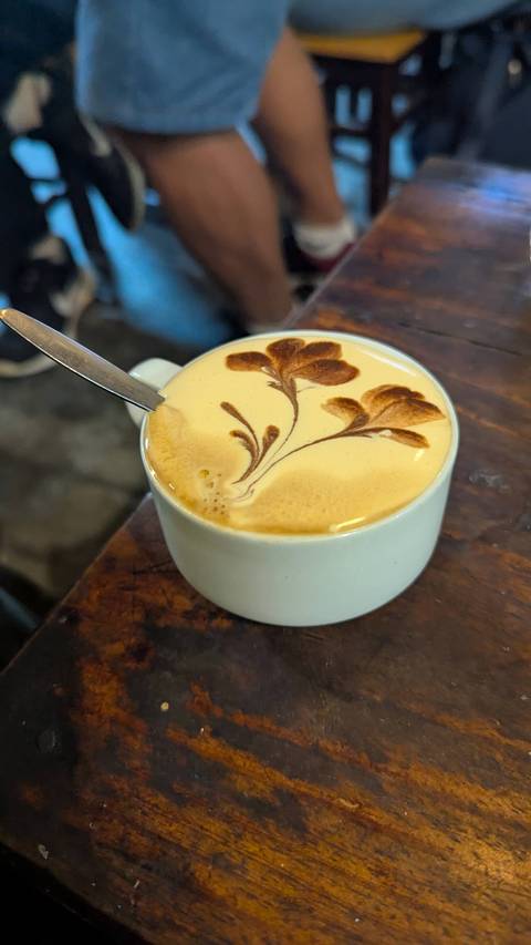      A cup of coffee with intricate latte art.
  