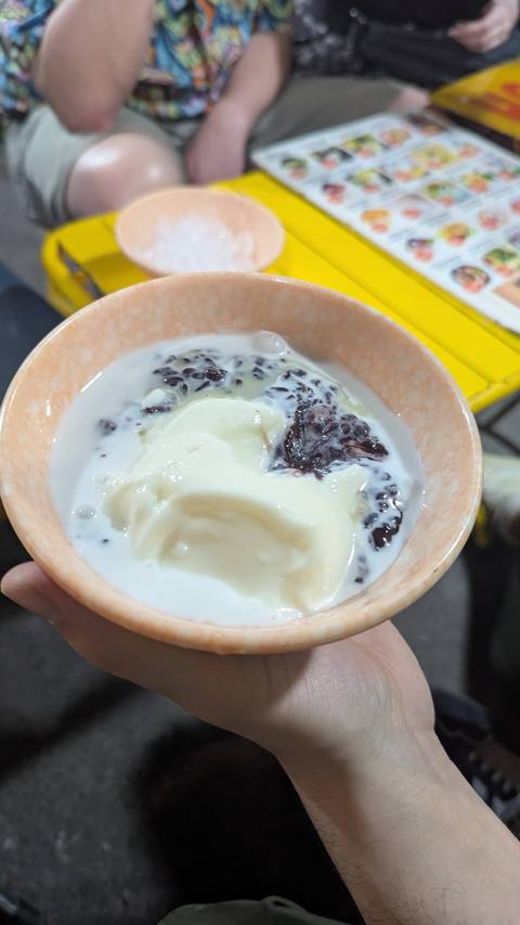       A bowl with a dessert of rice, black beans, and coconut milk.
  
