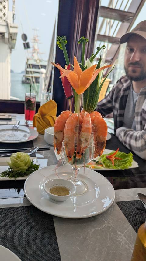       Shrimp cocktail elegantly displayed in a glass with vegetables.
  