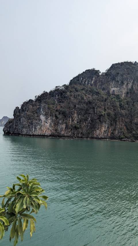       A rocky island cliff rising from the ocean.
  