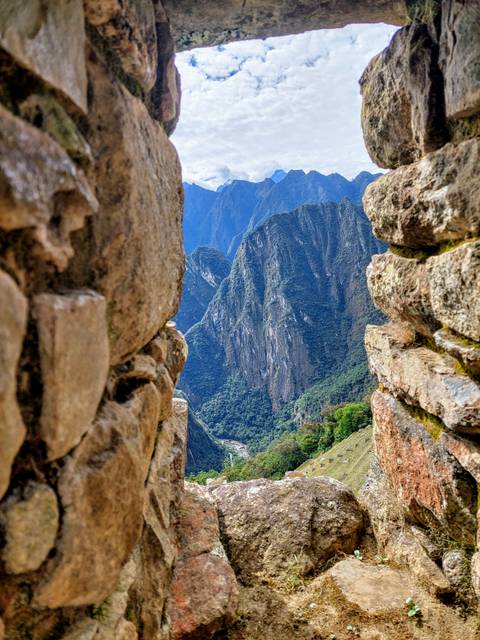       View through stone window with mountains
  
