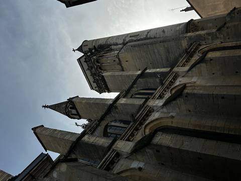 A tilted view of a large stone cathedral with gothic architecture.