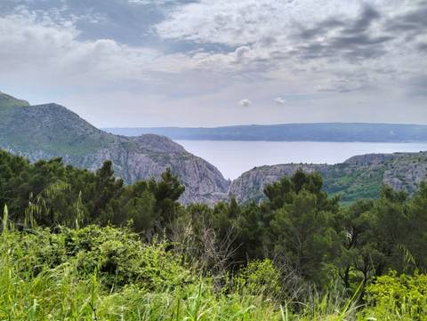       Mountainous view with cliffs and sea in the distance
  